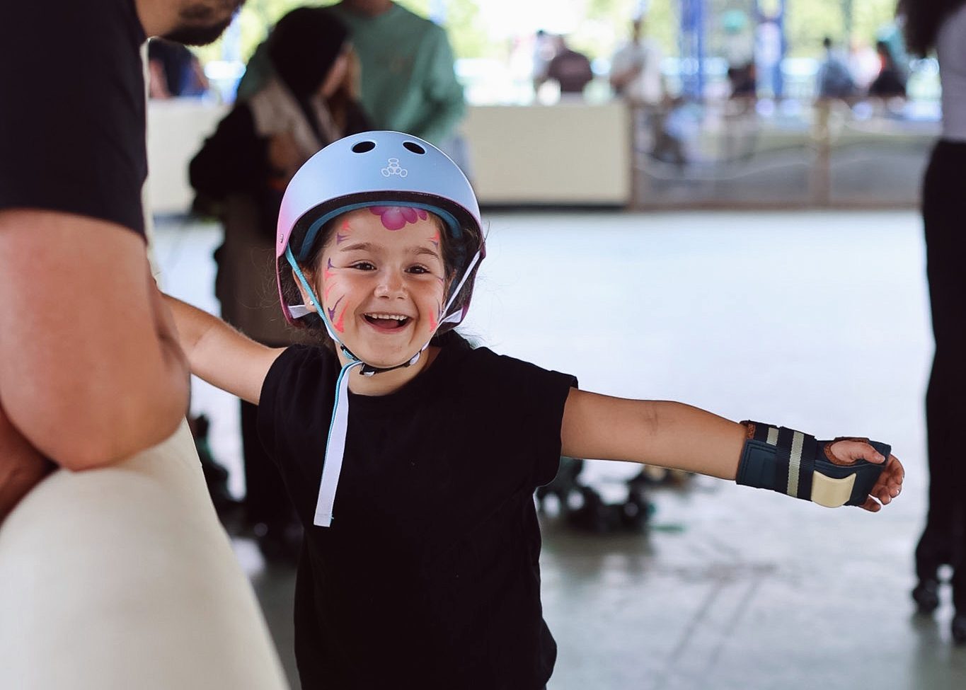 Een lachend kind met helm op de rolschaatsbaan van Spelen bij Beelen